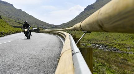 A motorcyclist rises along the newly resurfaced Kirkstone Pass road, alongside new wooden-clad crash barrier