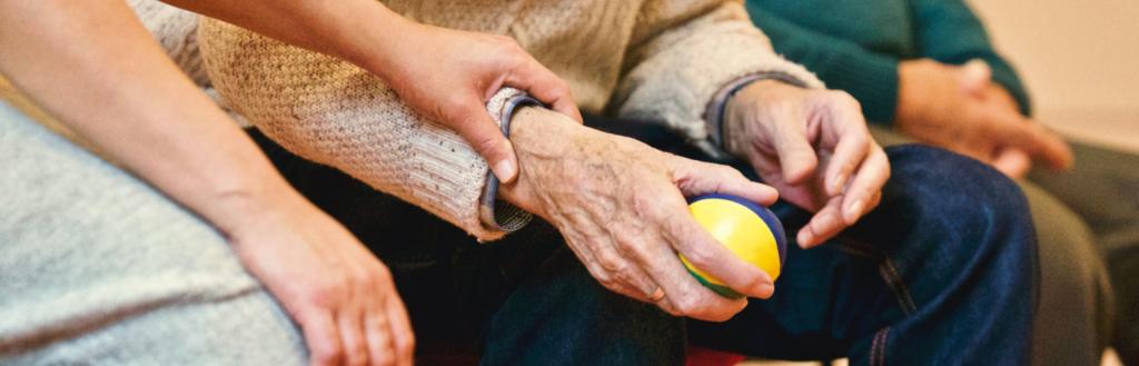 A lady holding the arm of an elderly person