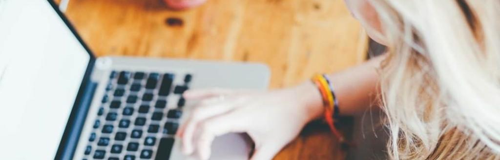 A woman typing on a laptop at a table.