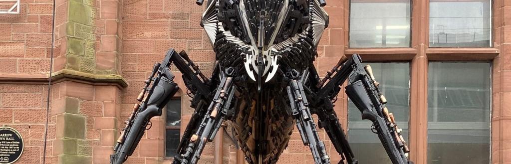 A bee sculpture made out of guns and knives on display outside Barrow Town Hall.