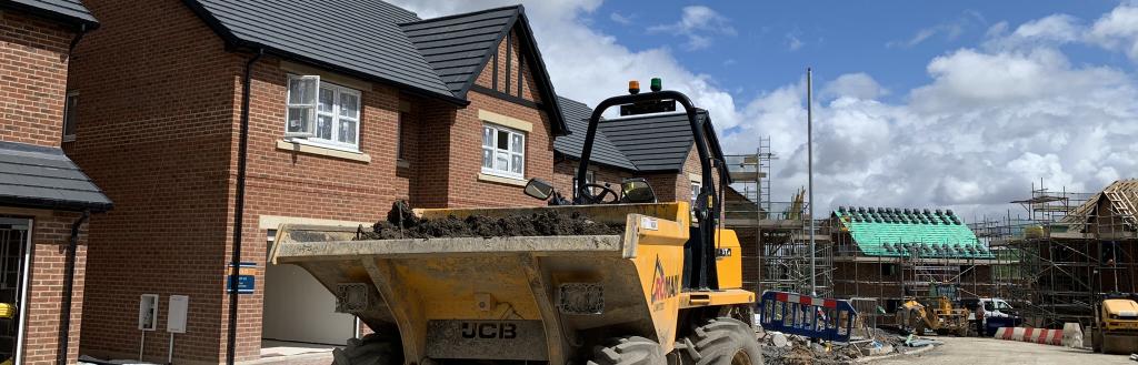 A dumper truck outside a house.